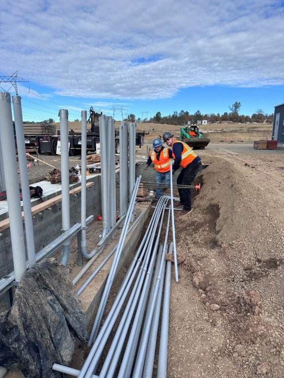 Close-up of workmen installing electrical conduit at a construction site