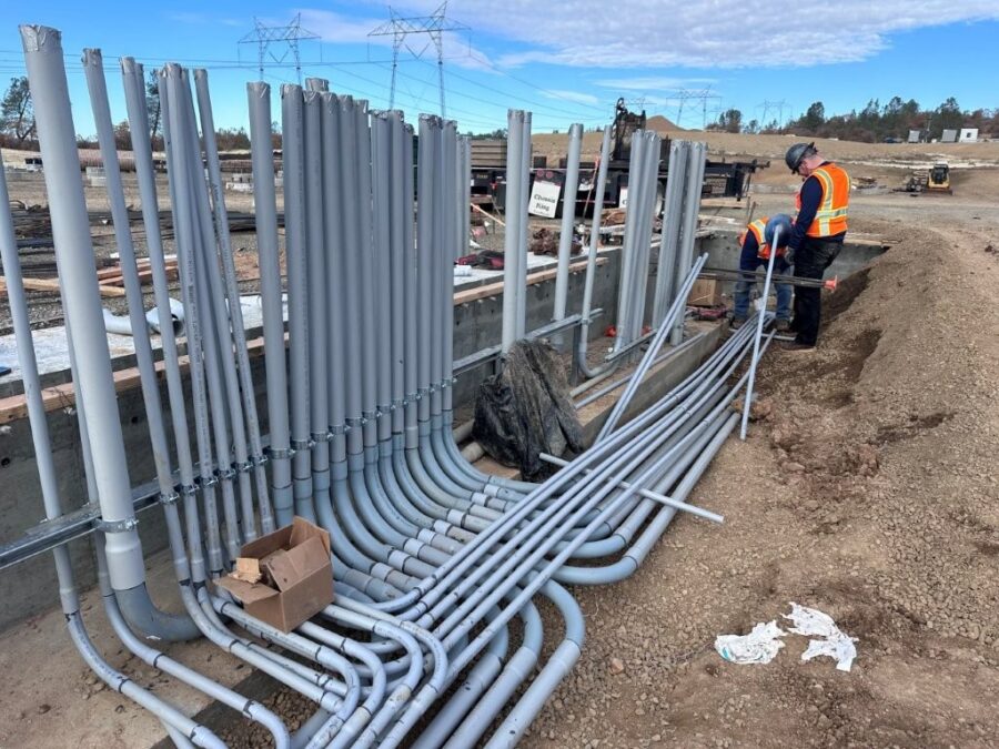 Workmen installing electrical conduit at a commercial construction site