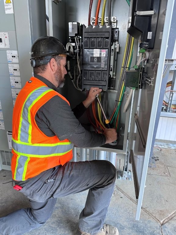 Electrician working on connections in an electrical panel