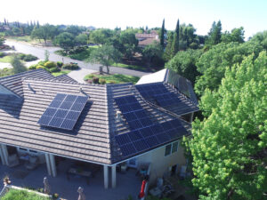 Drone view of home with solar panels on steep roof